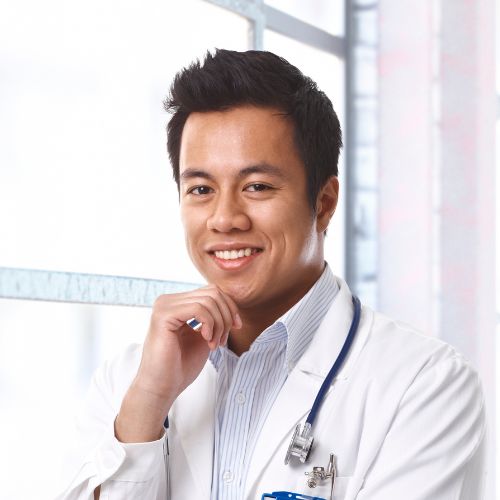 A male doctor is smiling for the camera.